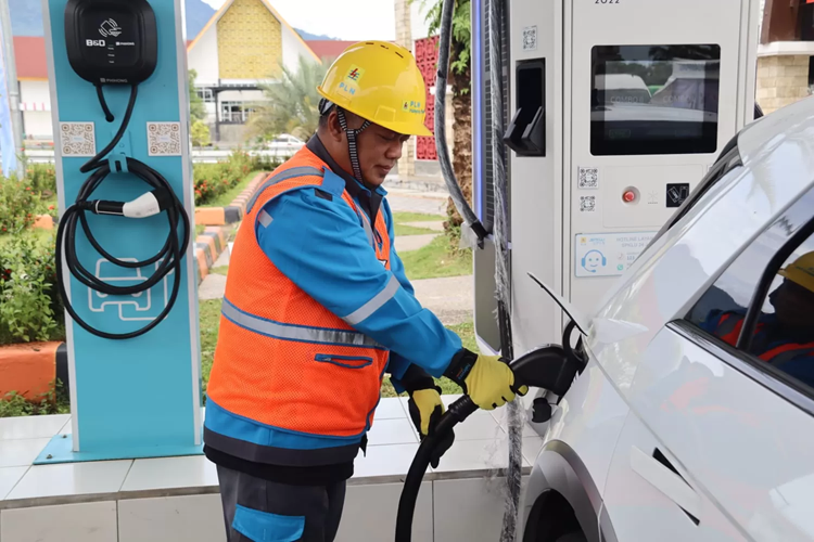 Petugas PLN membantu pengguna kendaraan listrik melakukan pengisian daya di SPKLU Rest Area Jalan Tol Trans Sumatera. (Foto: Urbancity.co.id/Pool/Dok. PLN)