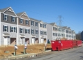a row of houses with a red truck parked in front of them